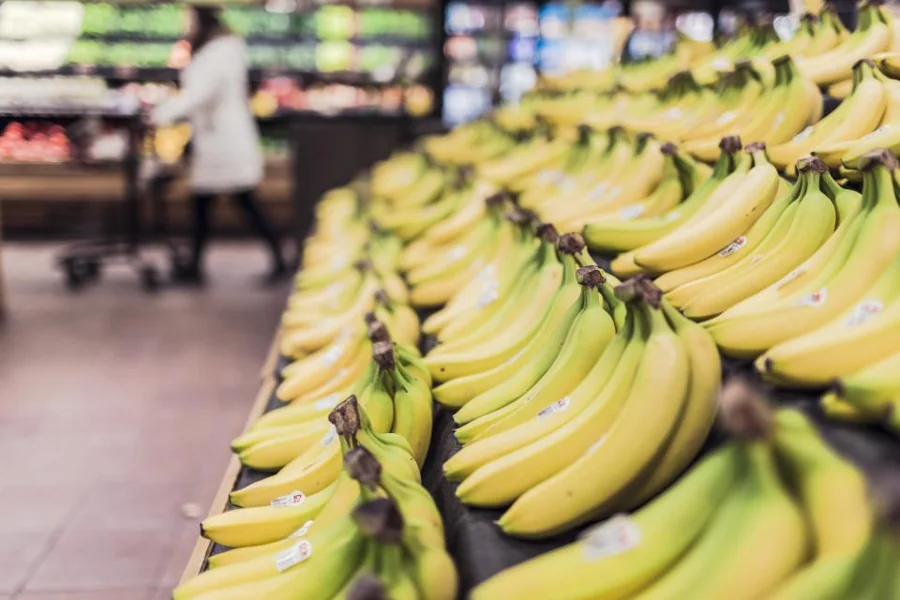 Supermarket produce aisle with a shopper in the background
