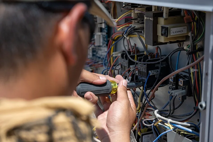 Technician working on the electrical panel of a refrigeration unit